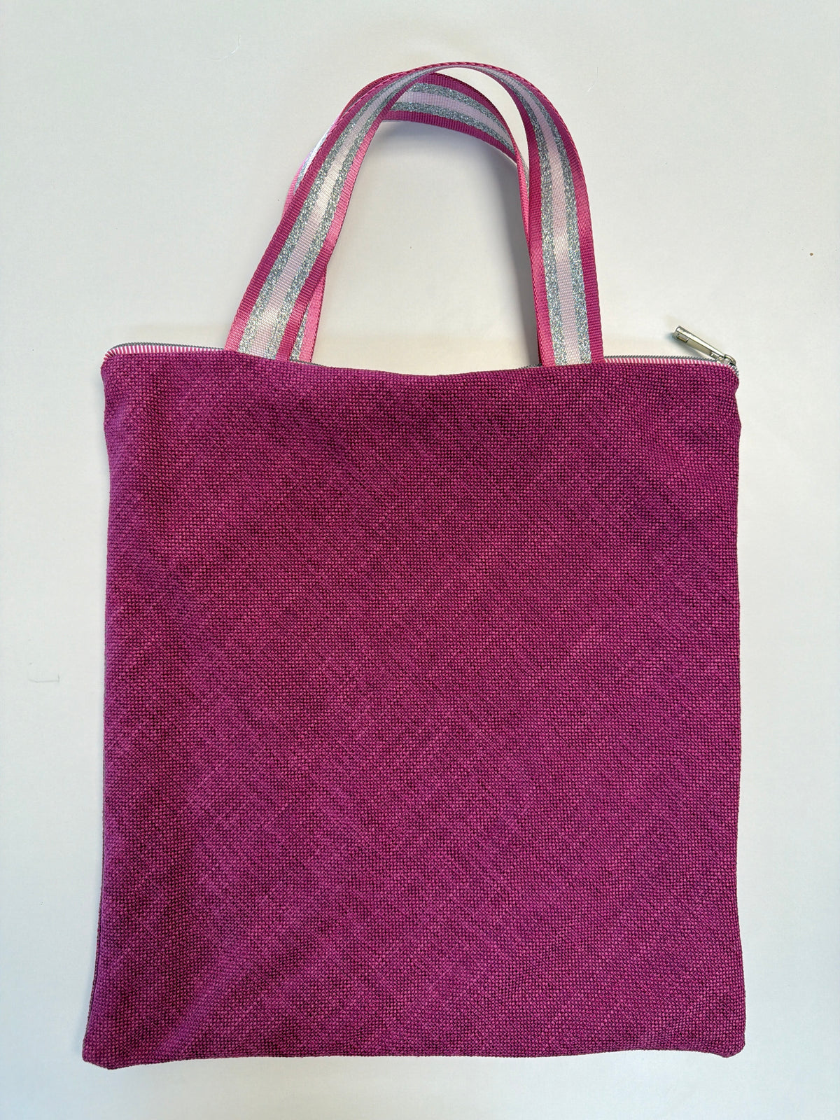 Magenta zip-top tote bag with light pink striped handles and textured fabric