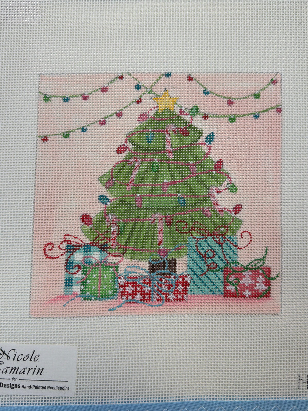 Decorative Christmas tree with green lights and wrapped presents at the base