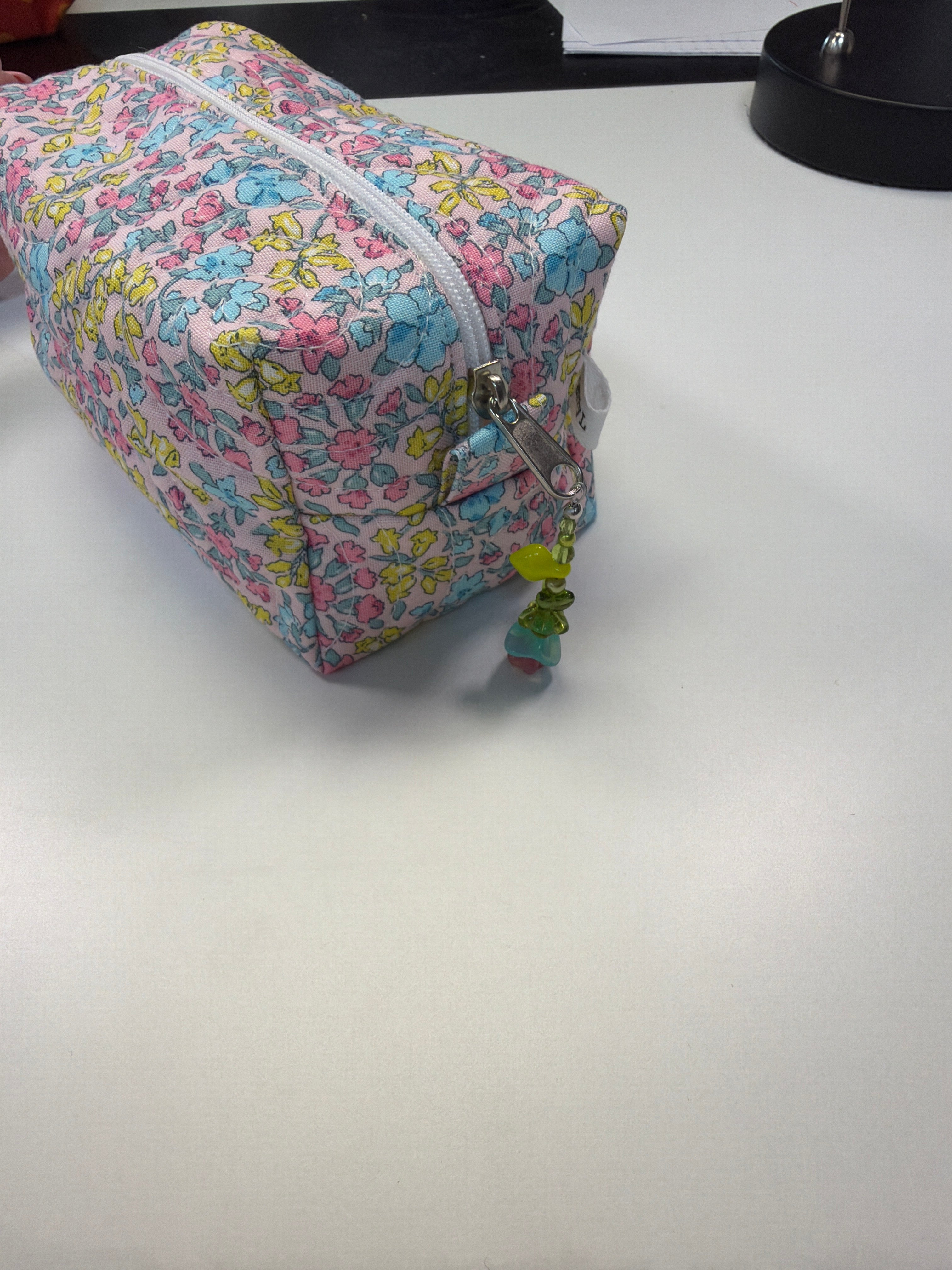 Large quilted zipper pouch, multicolor floral print, side view, top zipper and tassel pull
