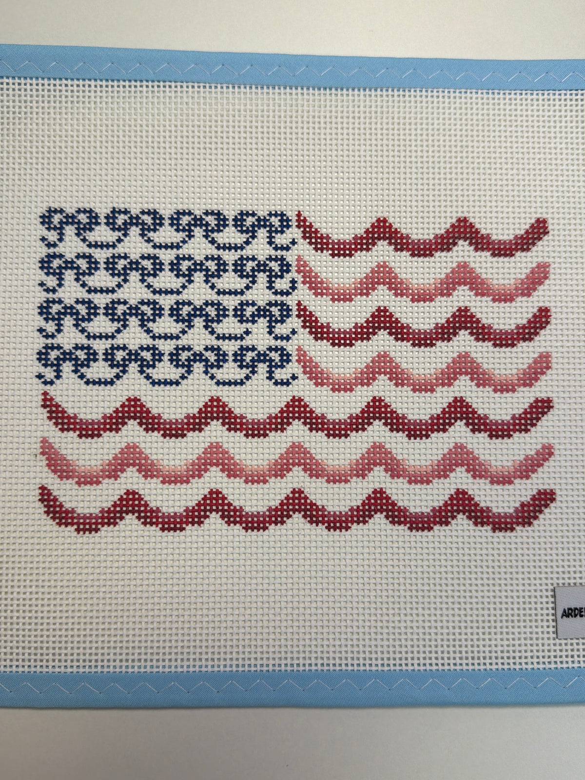 Decorative bow flag with blue lattice and red-and-white zigzag stripes