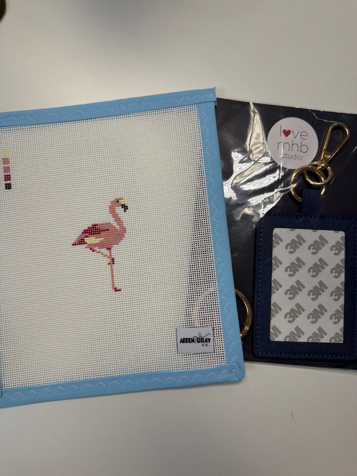 Flamingo cross-stitch patch keychain with blue fabric border and metal key ring