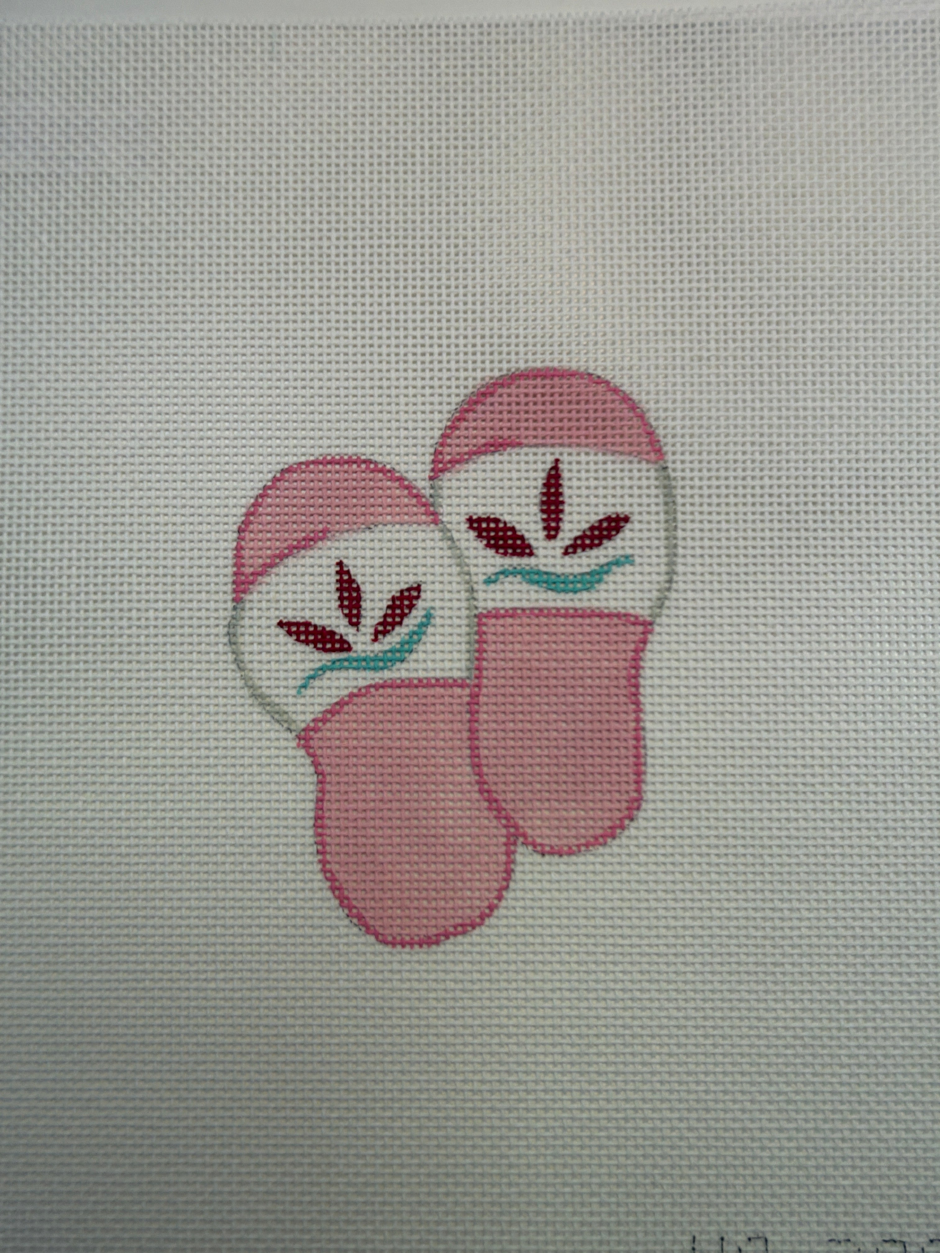 Pair of cartoon pink slippers with face details and steam lines, on light fabric
