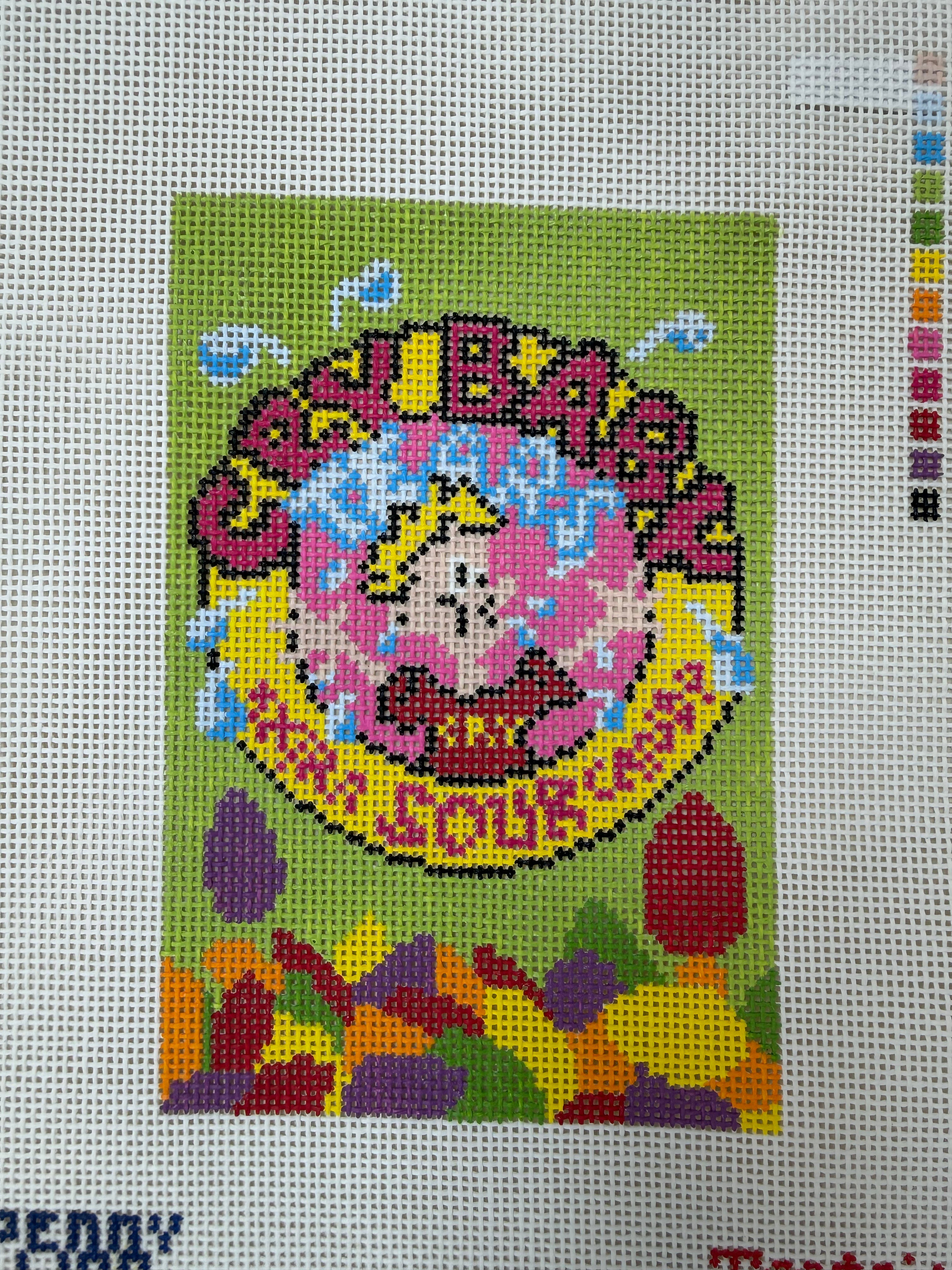 Green square pixel-art patch with crying face, rainbow tears, and floral trim