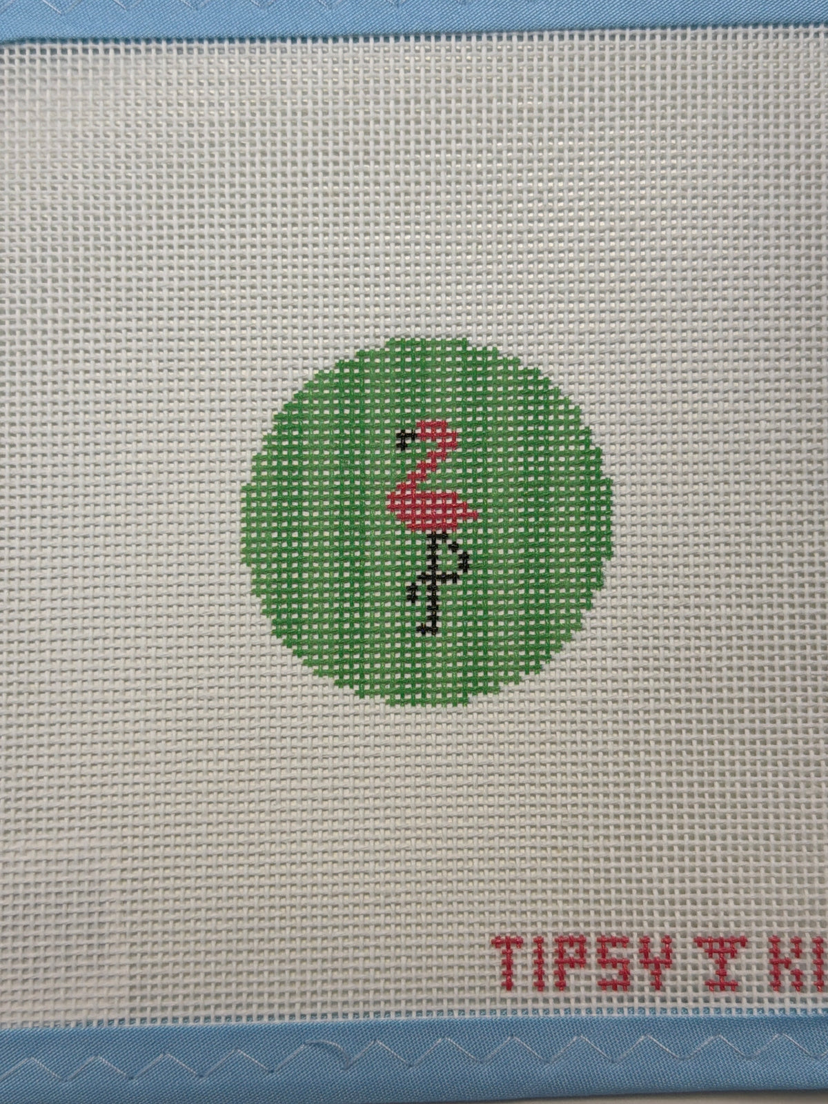 Green circular flamingo patch on light woven fabric