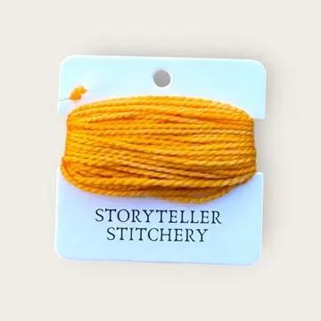 Hand-dyed embroidery thread spool in vivid orange on a card backing.