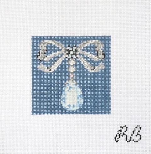 Blue fabric beaded bow with hanging white teardrop gemstone, detailed beadwork