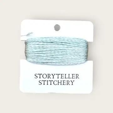 Hand-dyed embroidery thread spool, pale aqua blue on a card backing