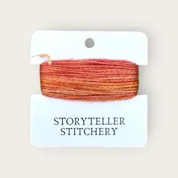 Hand-dyed embroidery thread spool, orange and tan tones on a card backing