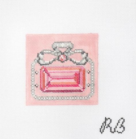 Square-cut gemstone with dark metal halo and pink central stone