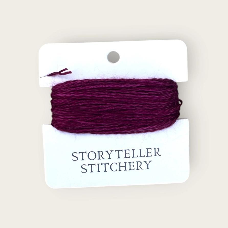 Hand-dyed embroidery thread on card, dark plum purple skein with tight windings