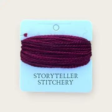 Hand-dyed embroidery thread spool, deep plum maroon, tightly wound