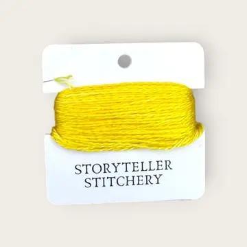 Hand-dyed yellow embroidery thread spool on labeled card