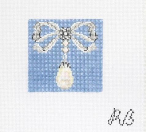 Light and white beaded bow with hanging white teardrop gemstone on blue fabric