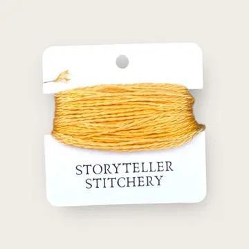Hand-dyed embroidery thread skein on card, golden yellow with slight variegation