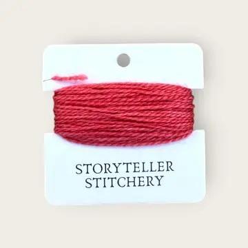 Hand-dyed embroidery thread spool, bright red on a card backing