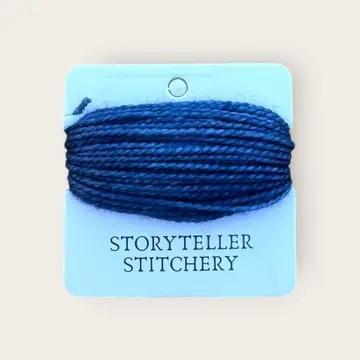 Hand-dyed embroidery thread spool, dark navy on a card backing
