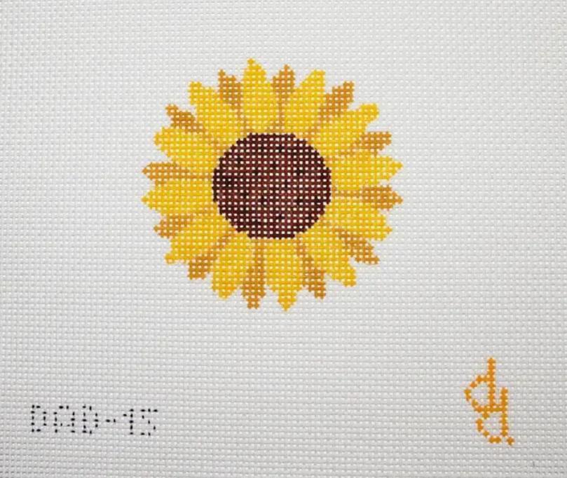 Embroidered sunflower patch with yellow petals and dark center on light fabric