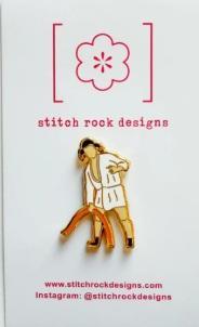 Stitch Rock needle minder: standing doll charm in gold and white on card