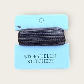 Hand-dyed embroidery thread skein, dark gray on a hanging display card