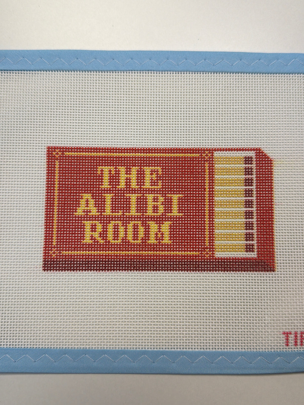 Matchbox-style label patch on beige fabric with red/yellow print