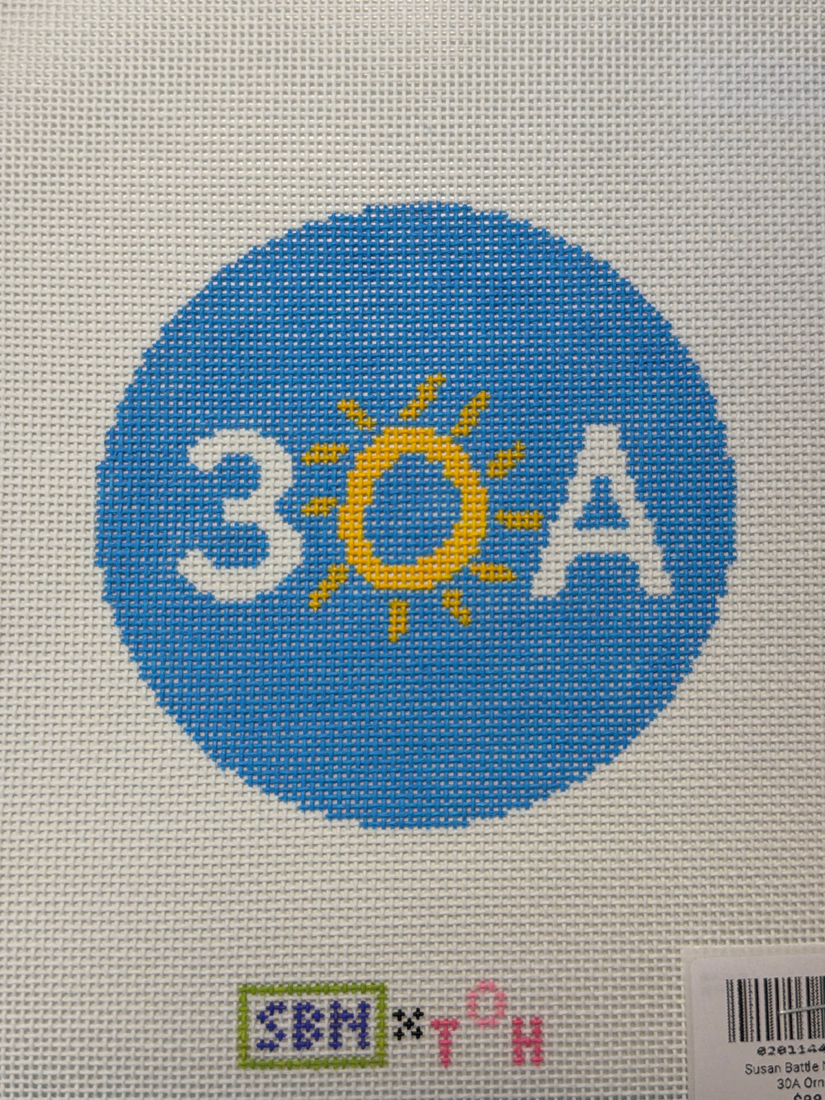 Round blue needlepoint canvas with letters and yellow sunburst design