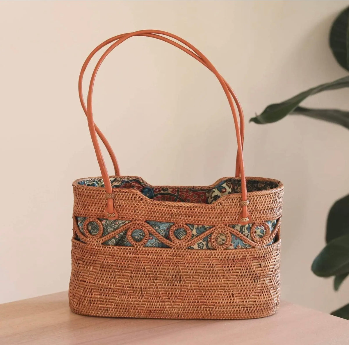 Rattan tote bag with decorative patterned trim along top, orange-brown woven body