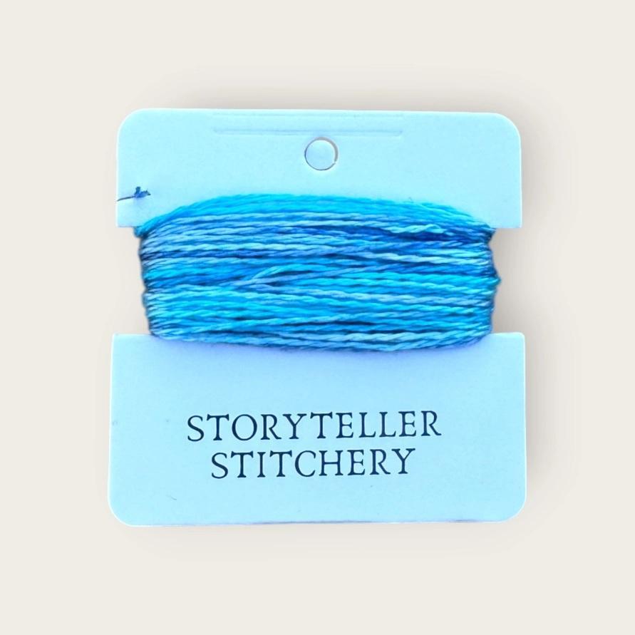 Hand-dyed embroidery thread on card, bright blue skein with visible winding