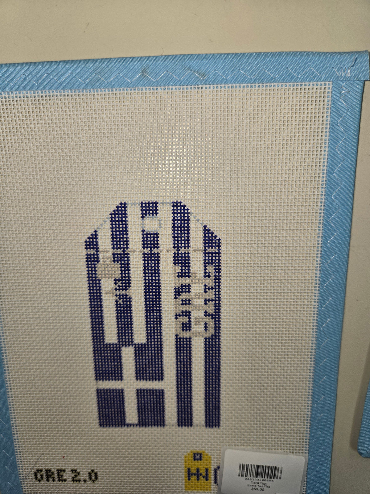 Cross-stitch travel tag with a blue-and-white striped design and Greek flag motif