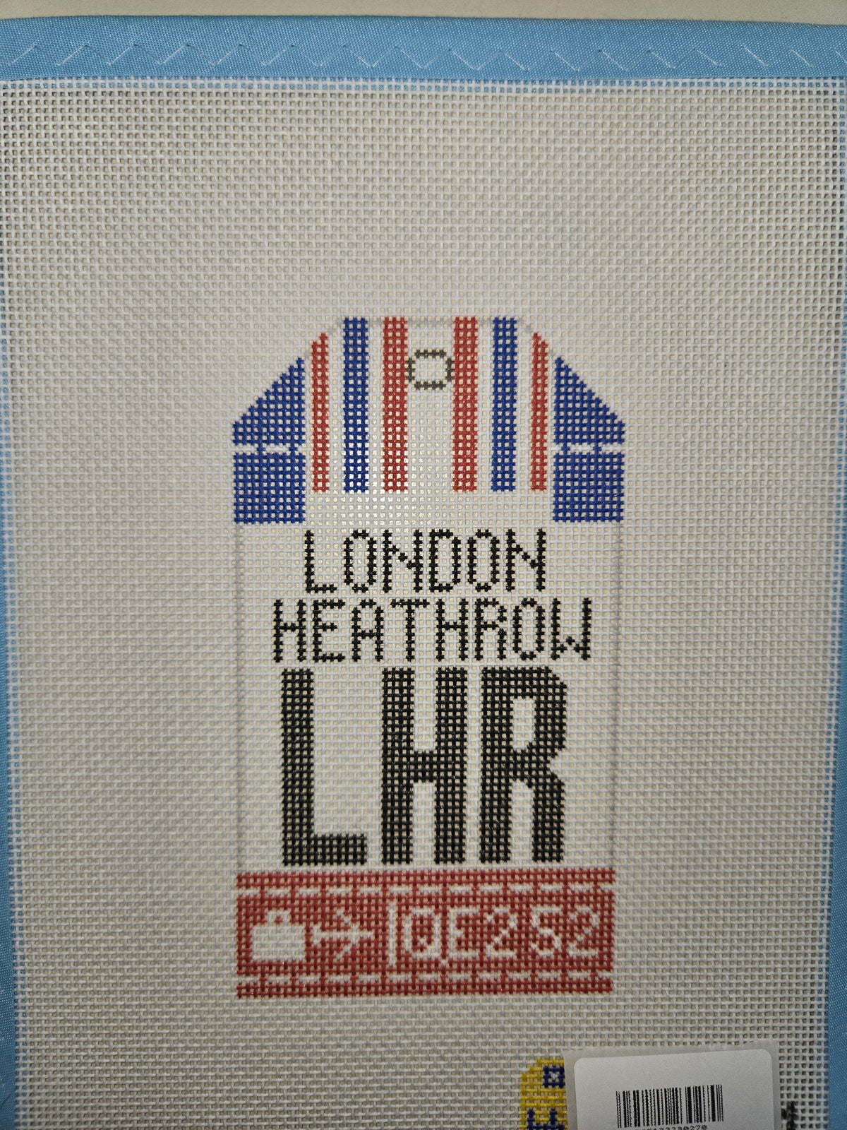 Cross-stitch London Heathrow travel tag with Union Jack motif and LHR lettering