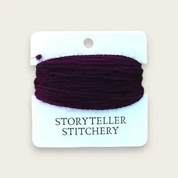 Hand-dyed embroidery thread spool in dark plum on a card backing.