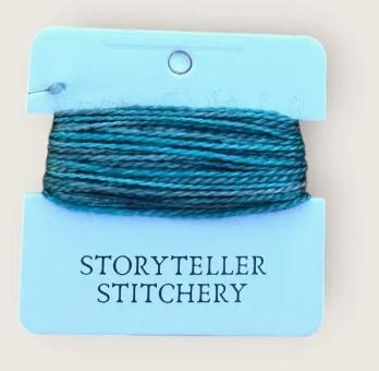 Hand-dyed embroidery thread spool, teal blue tones, tightly wound