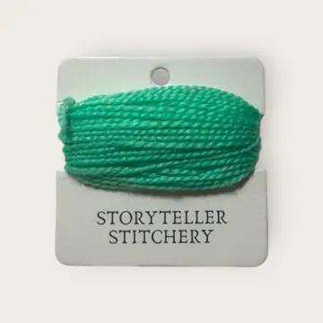 Hand-dyed embroidery thread spool in rich green on a card backing.