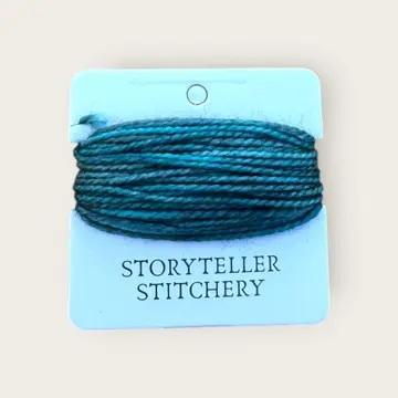Hand-dyed embroidery thread skein, teal-blue on a hanging display card