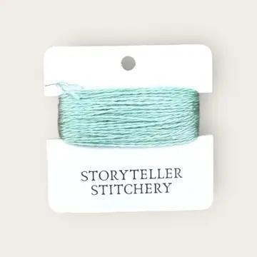 Hand-dyed embroidery thread on card, teal-aqua skein with fine textured fibers