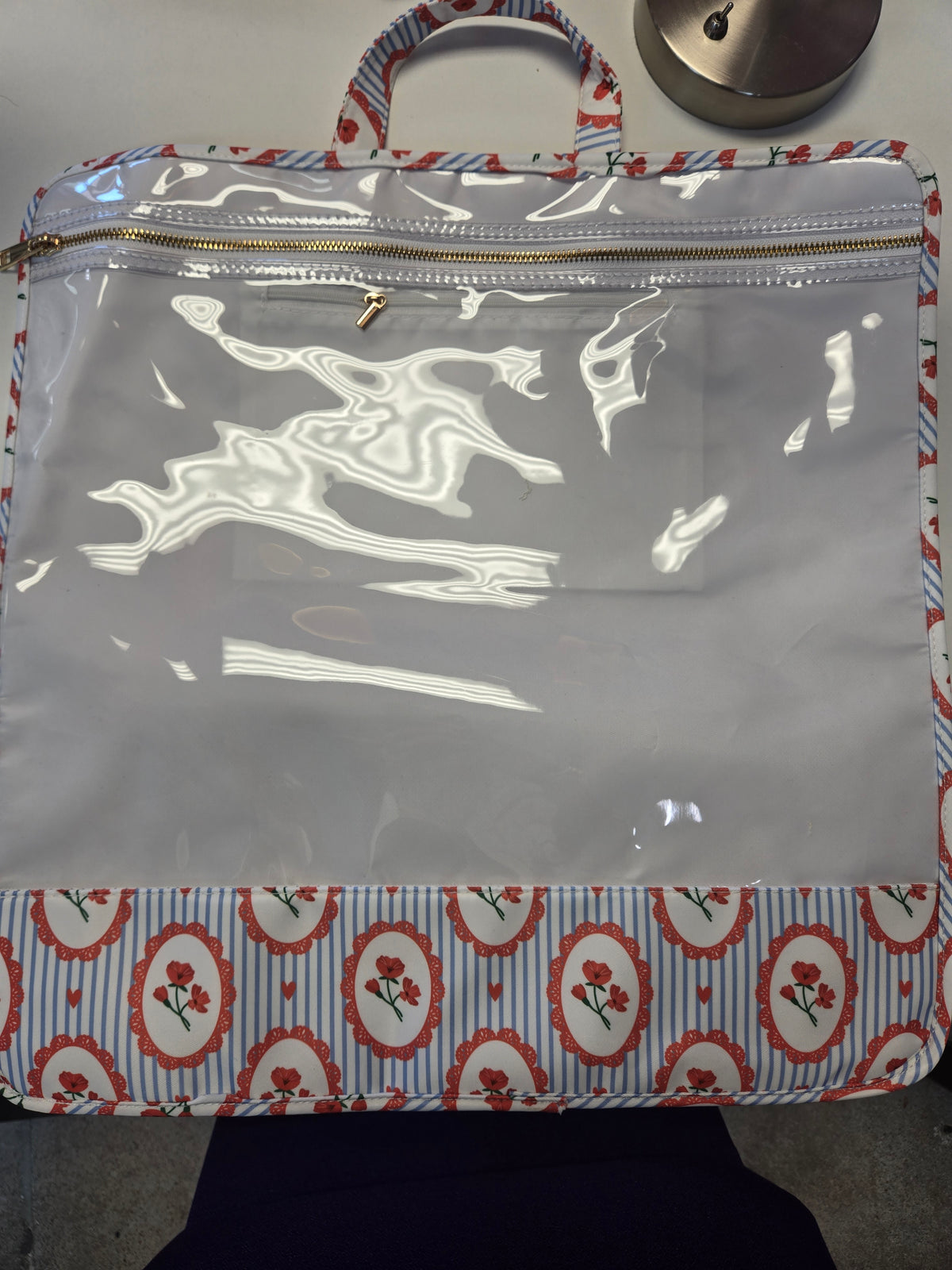 Tote bag with clear front panel and white abstract graphic, striped handle and zipper