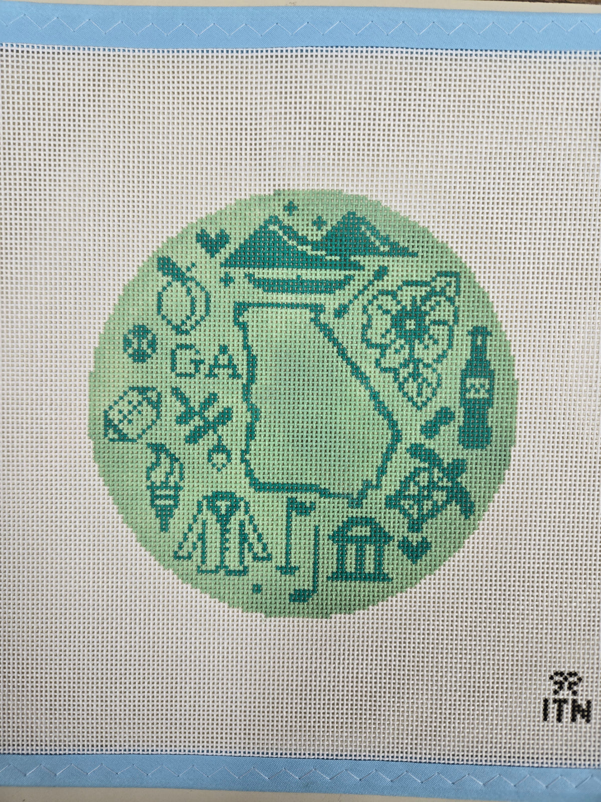 Round embroidered emblem patch with teal decorative icons design on light fabric