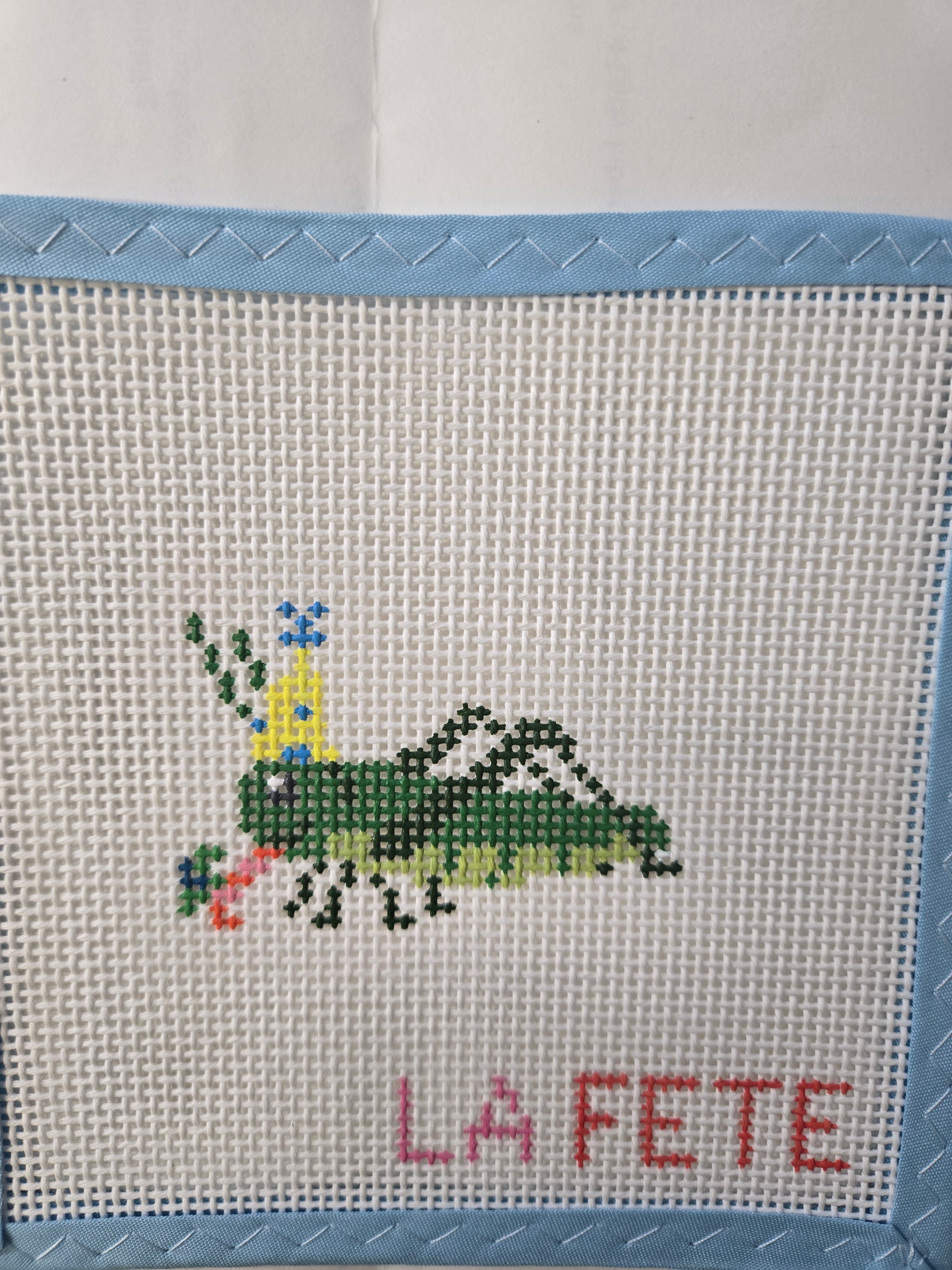 Grasshopper cross-stitch panel with green bug and red “LILY FETE” text