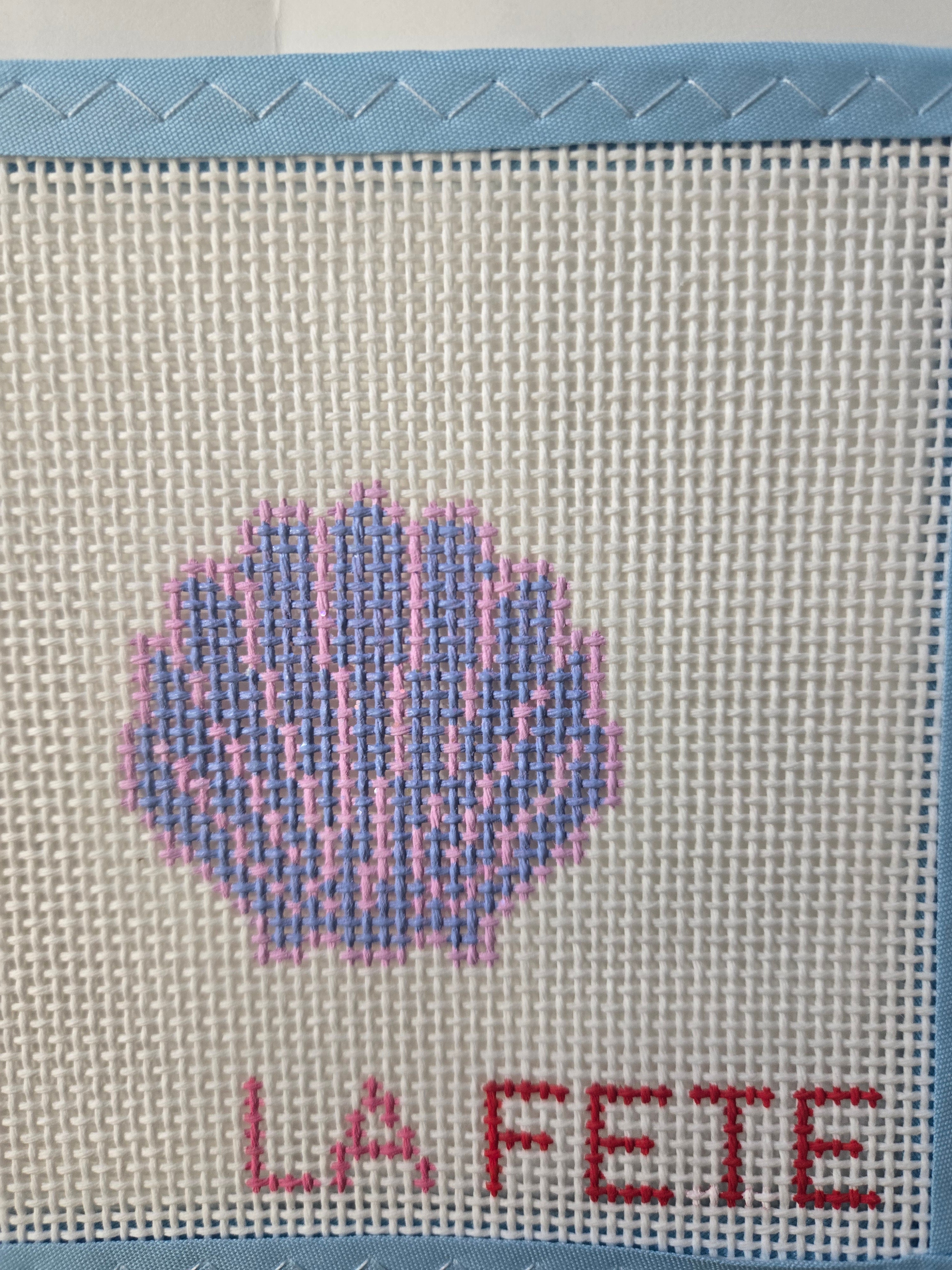 Light blue canvas with glittery seashell cross-stitch motif and red 'LIFE' text