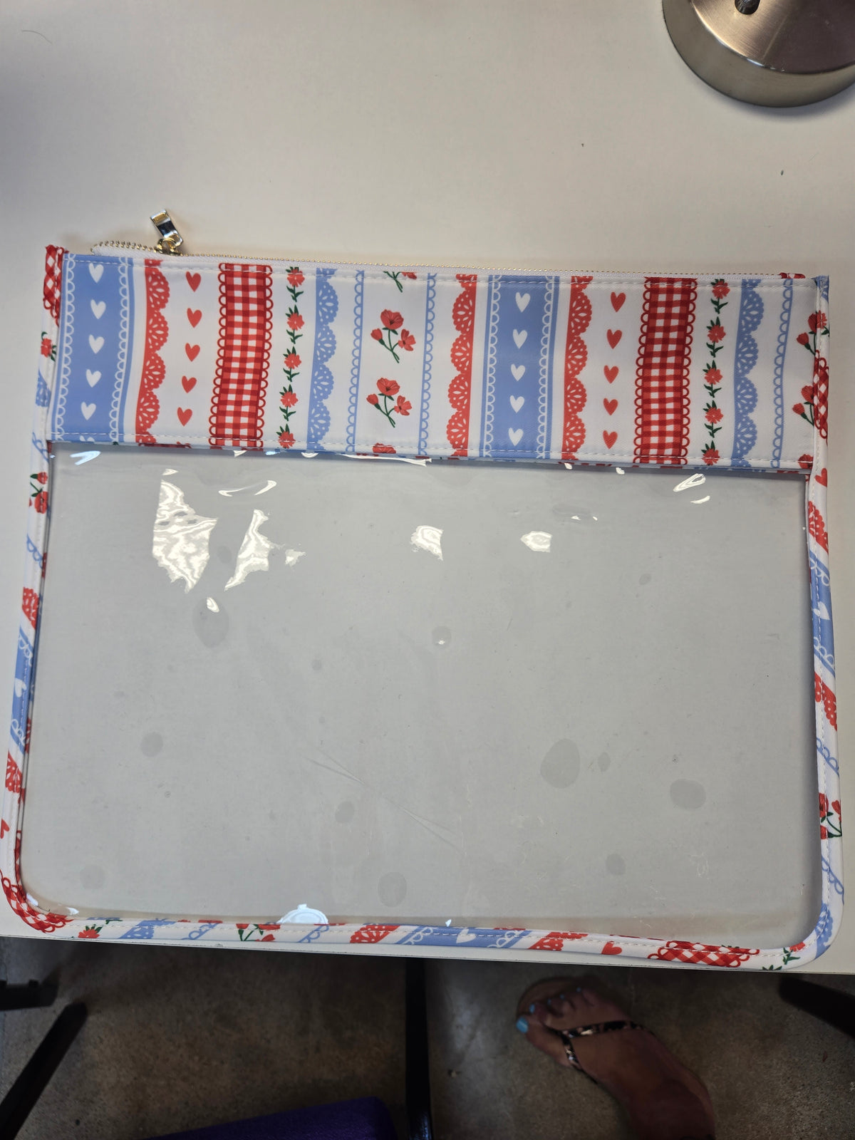 Zippered tote bag with red, blue, and floral patterned lining and interior compartment