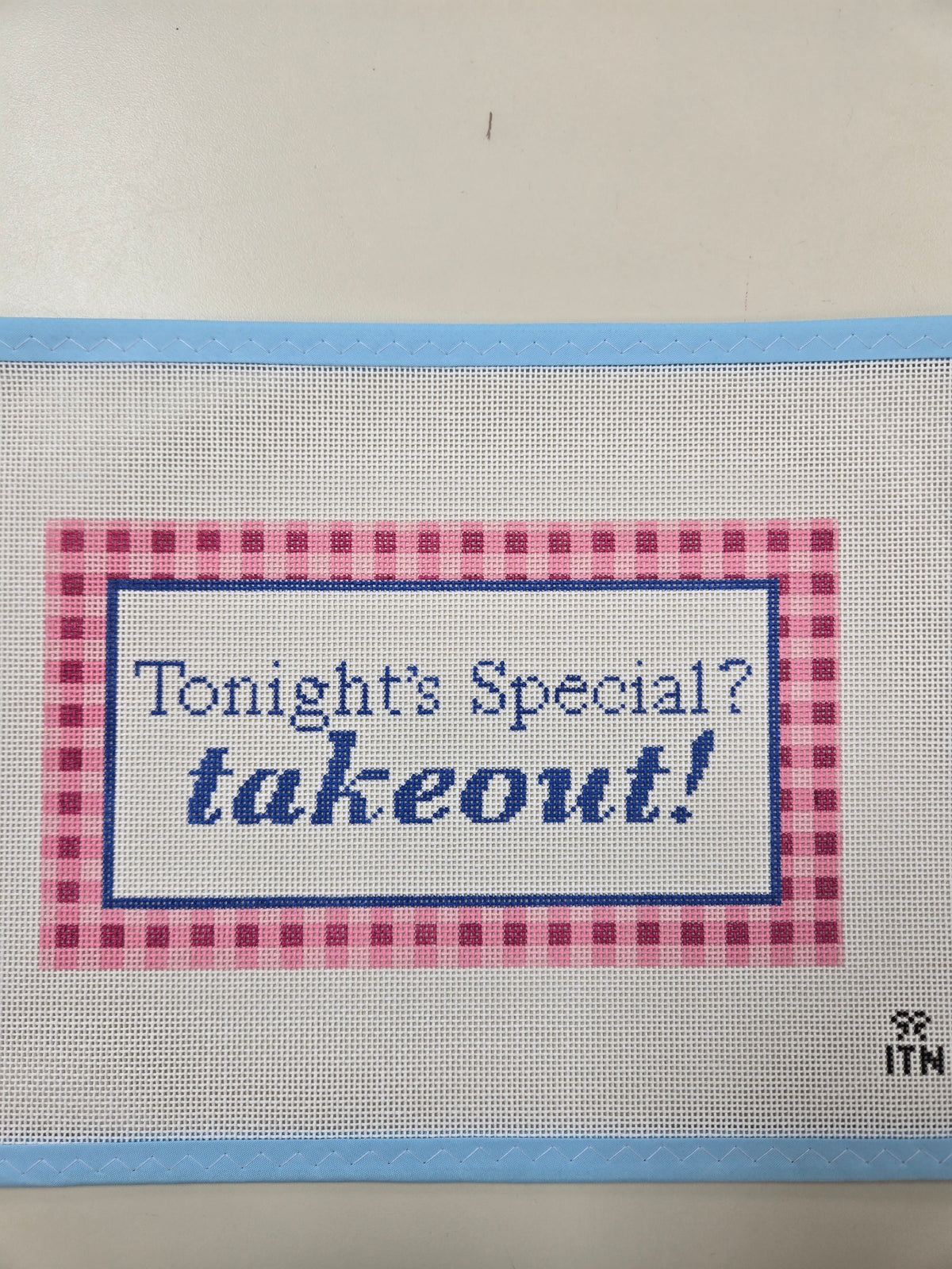Text graphic patch with blue lettering and red gingham border